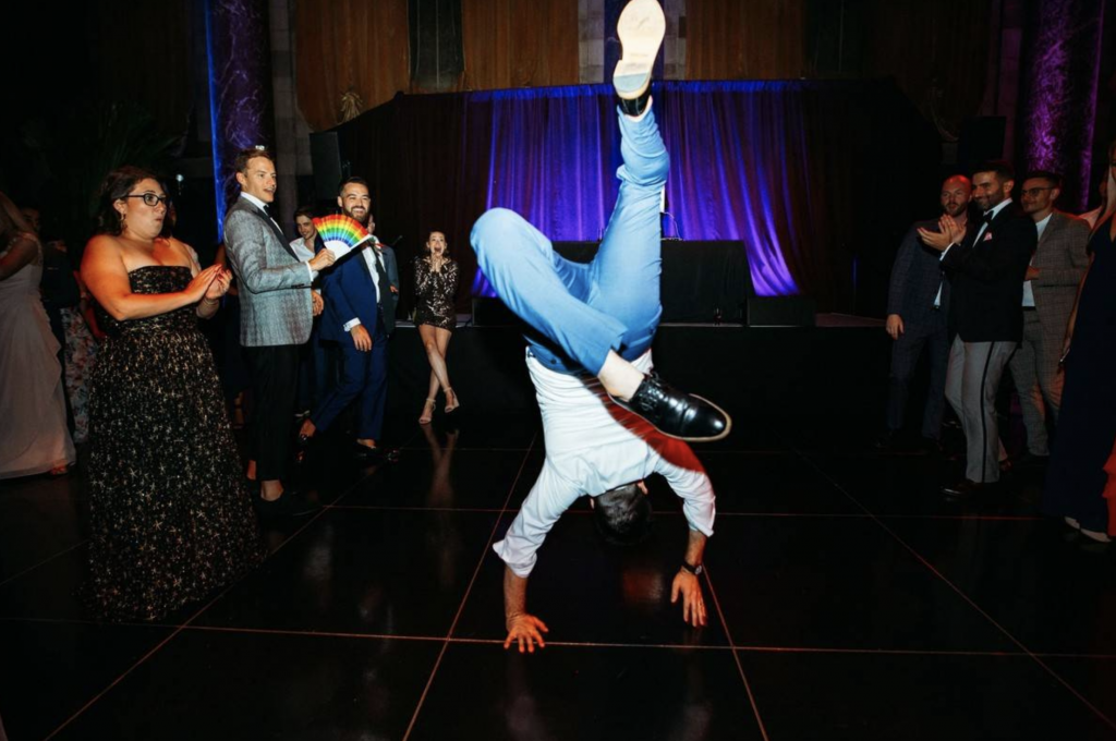 Guy doing a handstand at dance party