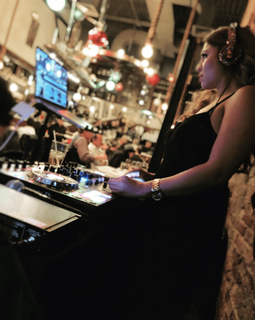 DJ Jenn Love Djing at a swanky lounge with DJ controller