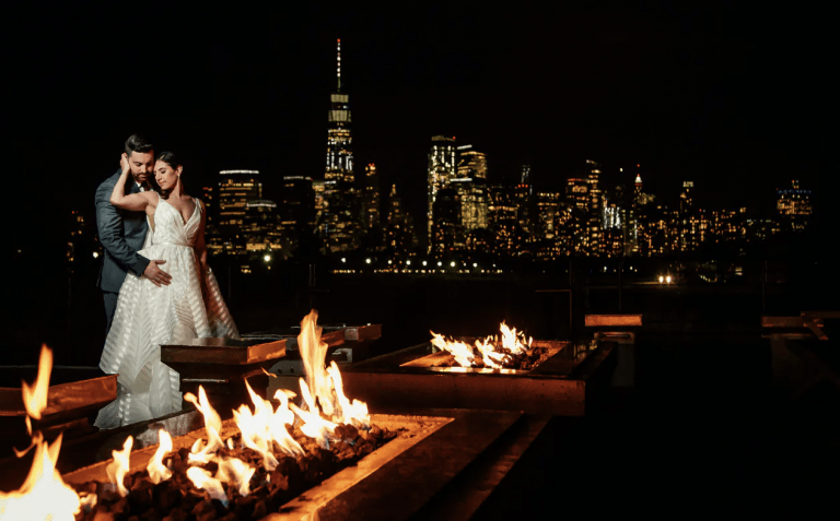 Bride & groom hugging outdoors at Liberty House with Manhattan skyline behind them