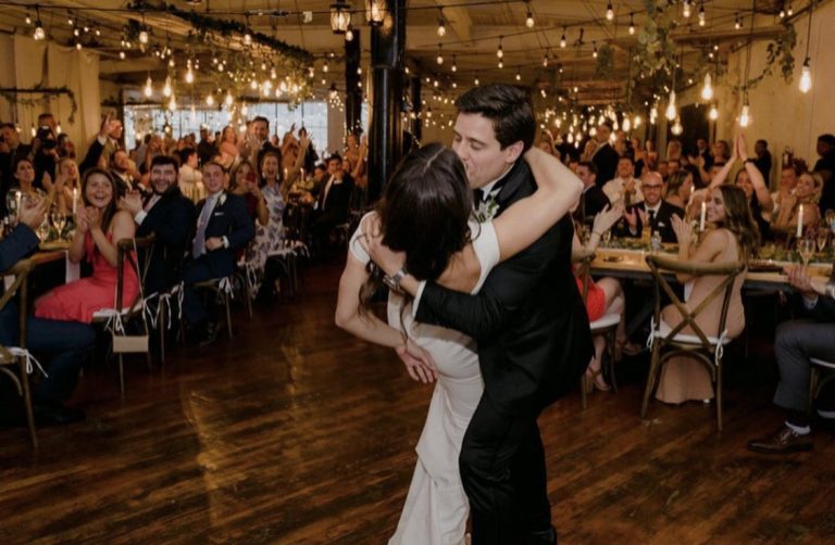 Groom dipping bride kissing her at art factory studios