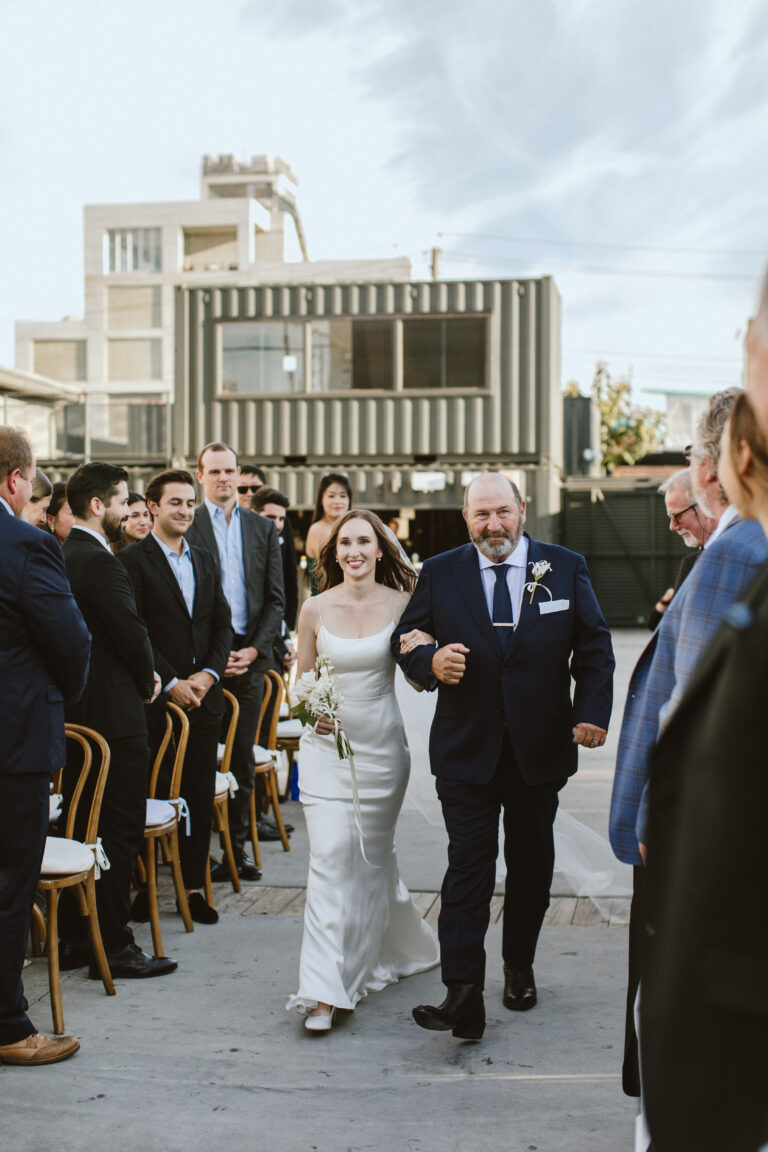 jessica and her father walk down the isle with bushwick in the background