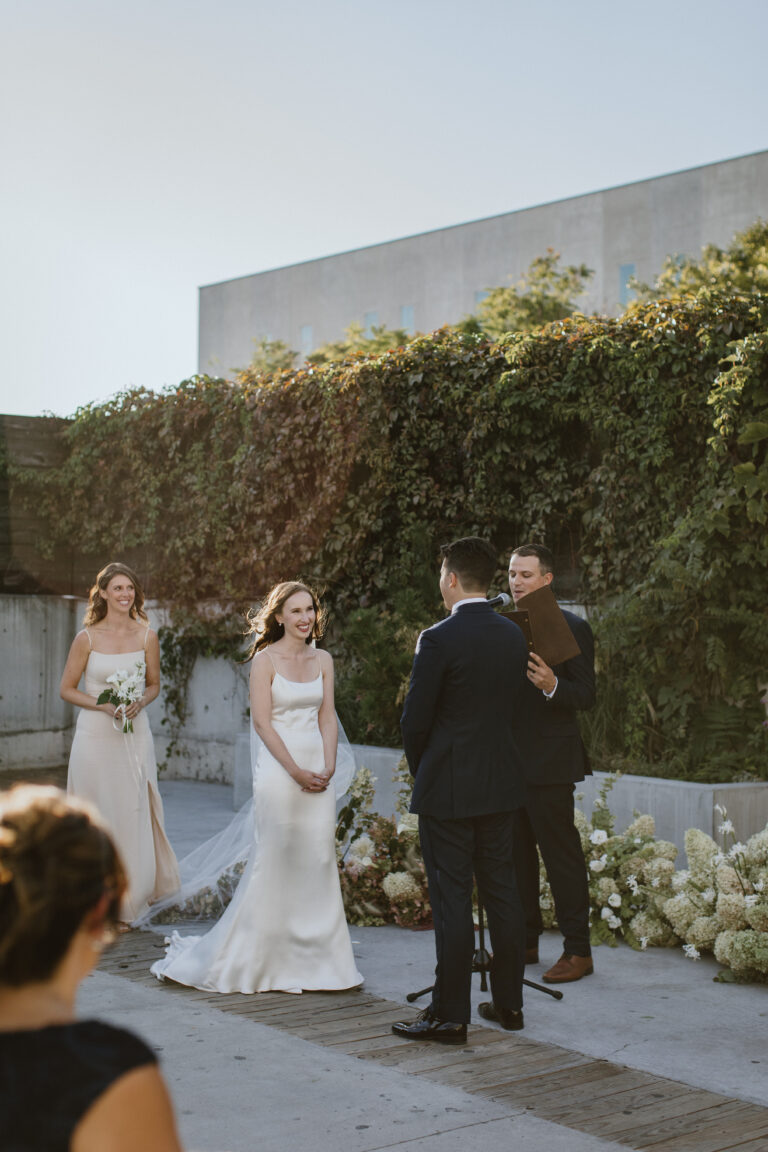 Mike and Jessica, and Maid of Honor smiling at the altar