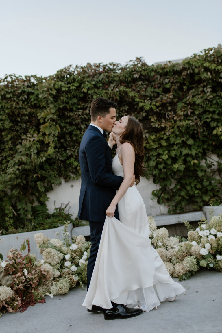 Mike and Jessica kiss with floral background
